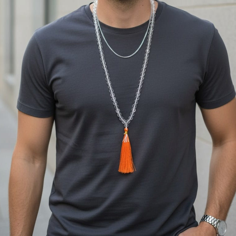 Clear Quartz Crystal Mala for Jaap- 108 beads worn by a person with an orange tassel against a dark t-shirt.