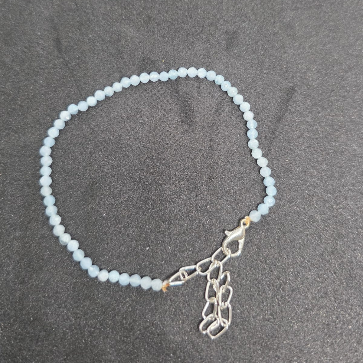 Aquamarine Anklet featuring natural crystal beads and a delicate silver clasp, promoting calmness and clarity.